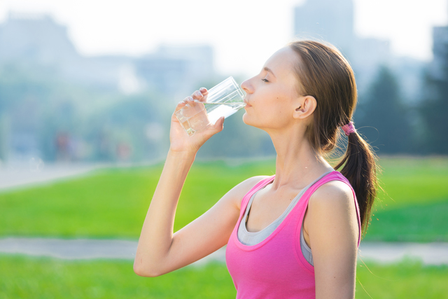 Portrait of woman drinking water after sport